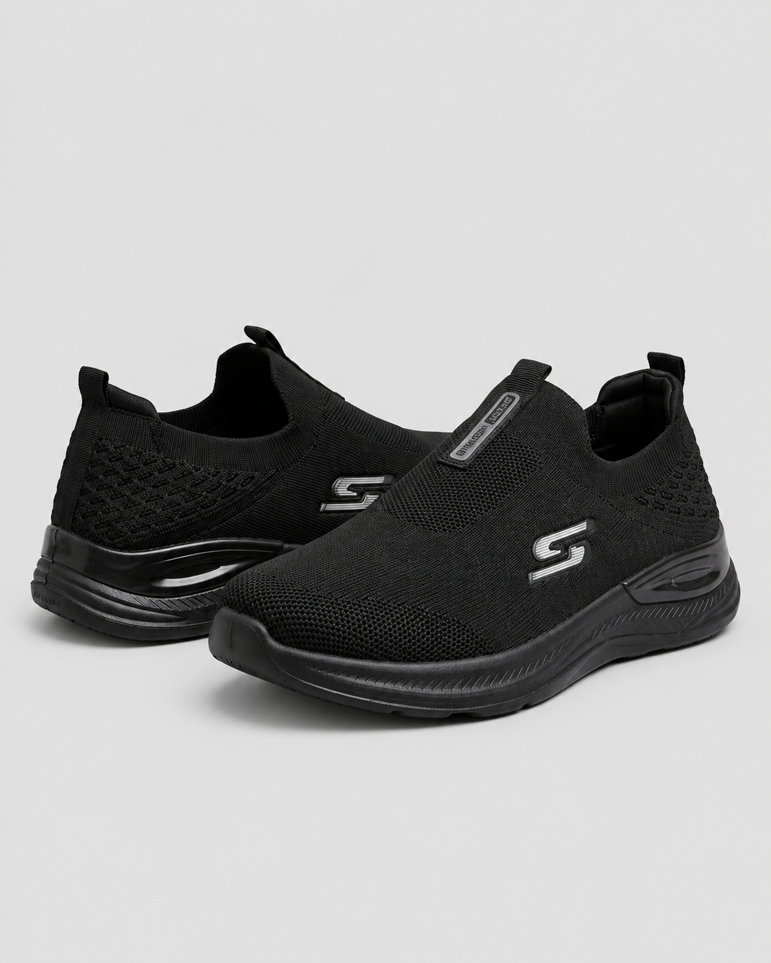 Black Comfort Knit Slip-On Skechers — studio light grey background